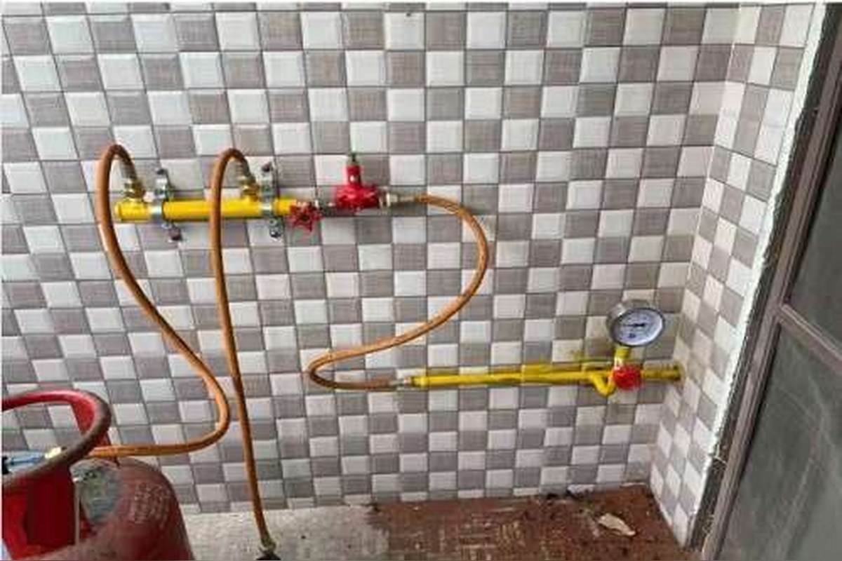Brass valves, regulator and copper connections on a gas line feeding a kitchen